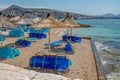 View of empty beach - blue deck chairs and shade umbrellas Royalty Free Stock Photo