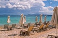 View of empty beach - white deck chairs and umbrellas near sea water Royalty Free Stock Photo