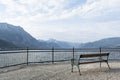 View of an empty bench on a gloomy cloudy day that stands on the embankment of a lake in the mountains. Concept landscape, Royalty Free Stock Photo