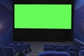 View of the empty cinema hall and a large green screen from the top rows. Cinema with rows of blue chairs Royalty Free Stock Photo