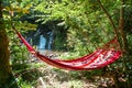 view of empty hammock between trees waterfall on background Royalty Free Stock Photo