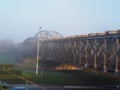 View of the empty iron steel bridge over the San River during sunrise with fog during summer in Przemysl Royalty Free Stock Photo