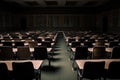 view of empty lecture hall, with rows of wooden chairs and a blackboard for note taking