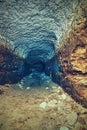 View into an empty medieval catacomb. Tunnel excavated in orange sandstone rock Royalty Free Stock Photo