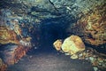 View into an empty medieval catacomb. Tunnel excavated in orange sandstone rock Royalty Free Stock Photo