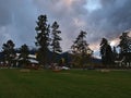 View of empty park area in small town Jasper, Alberta, Canada in the evening with green grass, benches and trees. Royalty Free Stock Photo