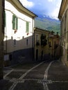 View of the empty road of the village with snowy mountains in the background, Abruzzo, Italy Royalty Free Stock Photo