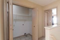 View of an empty shelf with wooden doors in a narrow hallway