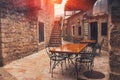 View of empty terrace of open-air cafe with tables and chairs in old town of Budva. Montenegro. Royalty Free Stock Photo