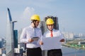 View of a Engineer and worker watching blueprint on construction site