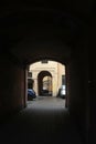 Dark arch and courtyard with parked cars Royalty Free Stock Photo
