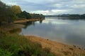 A view from the estuary of a large bridge in the background and a wooded area