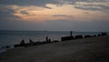 View of the evening sky over the ocean, with the silhouette of a shipwreck on the beach in the afternoon