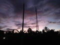 view of the evening sky with silhouettes of electricity poles and towers