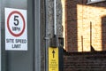 View of the exit of a private industrial site showing a site speed limit sign.