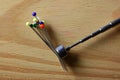 COLORED GLASS HEAD PINS STICKING TO TO MAGNETIC TOP OF A TELESCOPIC WAND