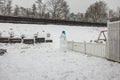 View of exterior of small garden with funny snowman in winter day.