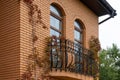 view of the facade of the building in the city, red brick house balcony with long windows, autumn decoration of the wall Royalty Free Stock Photo