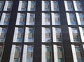 facade of a large black and white modern commercial building with repeating windows and geometric panels