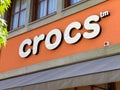 View on facade with logo lettering of Crocs shoes fashion company at shop entrance