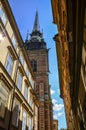 View on of facades of houses and the bell tower of the German church at old street in Gamla Stan in Stockholm, Sweden
