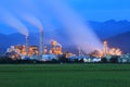 View of a factory in the middle of a green farmland in the early morning twilight