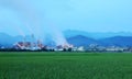 View of a factory in the middle of a green farmland in the early morning twilight Royalty Free Stock Photo