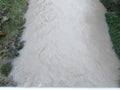 view of a fairly fast flowing river with murky brown water Royalty Free Stock Photo