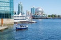 View of False Creek Ferries boat full of passengers on a sunny day with zscience World in the Background