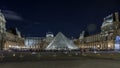 View of famous Louvre Museum with Louvre Pyramid at night timelapse hyperlapse. Paris, France Royalty Free Stock Photo