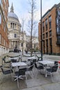 View of the famous St. Paul's Cathedral behind cafe tables with Christmas decorations on a cloudy day in London, England