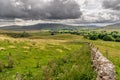 Fields and sheep on farm land in a valley with rain clouds