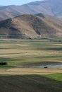 A view of farm land sitting below barren mountains at Cavustepe in the Van Province in Turkiye. Royalty Free Stock Photo