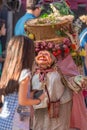 View of farmer doll, manipulated with people inside, carrying large traditional basket, at the Medieval market of Canas