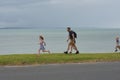 View of father and kids running on beach when rain starts