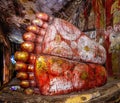 View of feet of lying Buddha Statue inside cave Golden temple in Dambulla, Sri Lanka