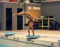 View of a female diver diving into the pool. standing on arms with legs up Royalty Free Stock Photo