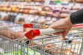 Female hand with pushcart in supermarket Royalty Free Stock Photo