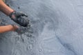 Female hands collecting mud in gray muddy water, Iceland Royalty Free Stock Photo