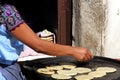 View of female indigenous hand making tortillas on comal, traditional food
