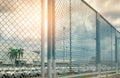 View from fence of car production factory to blurred parking area of new car stock. Many of car parked at parking lot of