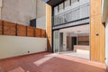 View from the fenced terrace inside a large house through large glass doors to a spacious modern kitchen. The facade of