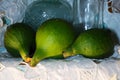 GREEN FIGS ON A SHELF WITH WHITE ANGLAISE CLOTH AND VINTAGE BOTTLES Royalty Free Stock Photo