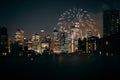 View of financial district Manhattan buildings and lights at night with fireworks at the sky Royalty Free Stock Photo