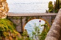 View on Fiordo di Furore arc bridge built between high rocky cliffs above the Tyrrhenian sea bay in Campania region. Boat floating Royalty Free Stock Photo