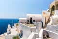 View of Fira town - Santorini island,Crete,Greece. White concrete staircases leading down to beautiful bay with clear blue sky