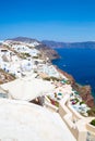 View of Fira town - Santorini island,Crete,Greece. White concrete staircases leading down to beautiful bay with clear blue sky Royalty Free Stock Photo