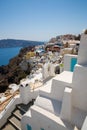 View of Fira town - Santorini island,Crete,Greece. White concrete staircases leading down to beautiful bay with clear blue sky and Royalty Free Stock Photo