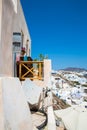 View of Fira town - Santorini island,Crete,Greece. White concrete staircases leading down to beautiful bay with clear blue sky and