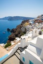 View of Fira town - Santorini island,Crete,Greece. White concrete staircases leading down to beautiful bay with clear blue sky and